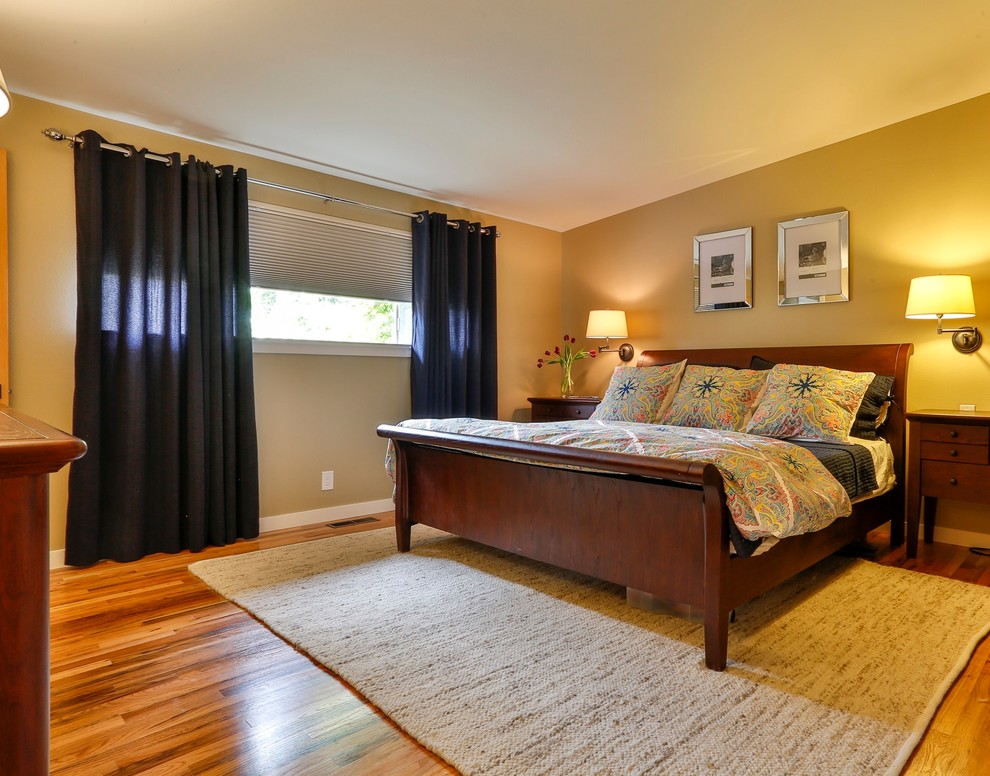 Cette photo montre une chambre parentale chic de taille moyenne avec un mur beige et un sol en bois brun.