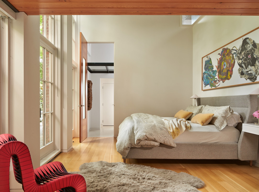 Großes Industrial Hauptschlafzimmer mit beiger Wandfarbe, hellem Holzboden und braunem Boden in Austin