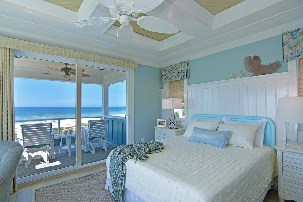 Cette photo montre une chambre parentale bord de mer de taille moyenne avec un mur bleu et parquet clair.