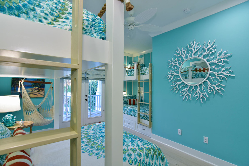 Foto de habitación de invitados costera de tamaño medio con paredes azules y suelo de madera clara