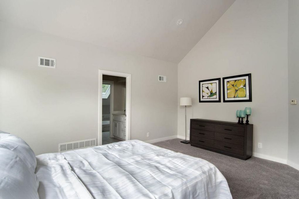 На фото: большая гостевая спальня (комната для гостей) в стиле неоклассика (современная классика) с серыми стенами, ковровым покрытием и серым полом