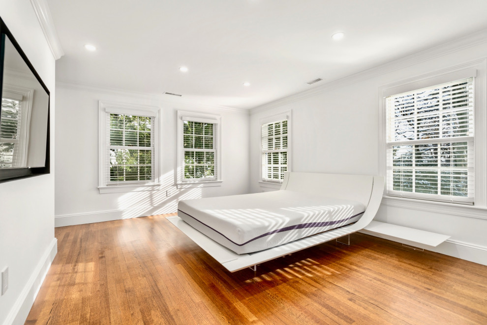 Diseño de dormitorio principal actual con paredes blancas y suelo de madera en tonos medios