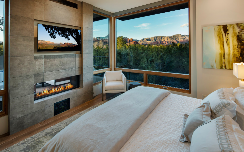 フェニックスにあるサンタフェスタイルのおしゃれな主寝室 (白い壁、両方向型暖炉)