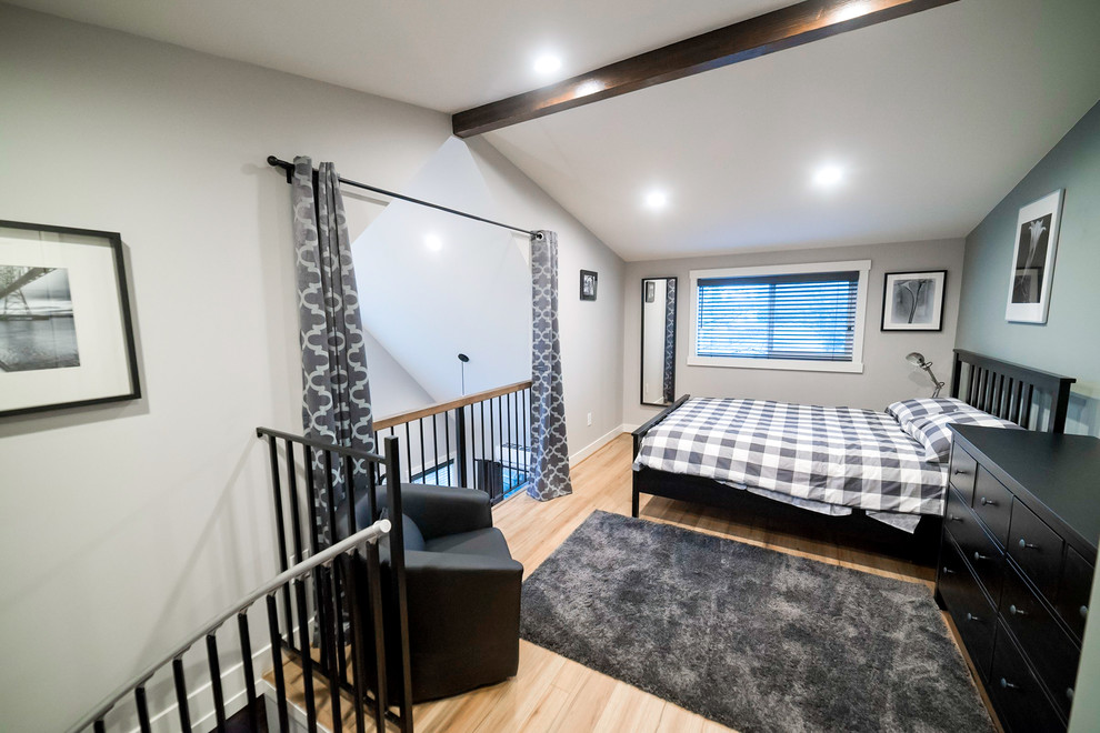 Modelo de dormitorio tipo loft tradicional pequeño con paredes grises y suelo de madera clara