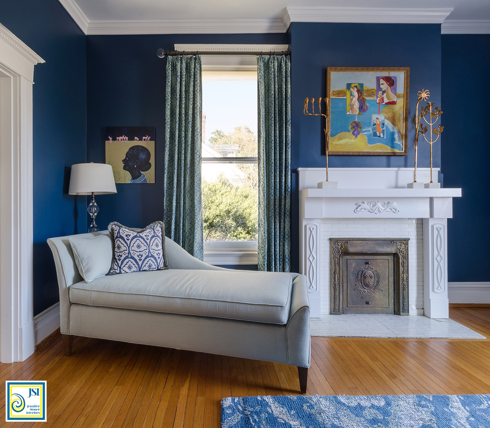 Mittelgroßes Klassisches Hauptschlafzimmer mit blauer Wandfarbe, braunem Holzboden, Kamin, gefliester Kaminumrandung und braunem Boden in Richmond