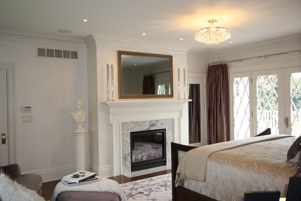 Стильный дизайн: хозяйская спальня среднего размера в стиле неоклассика (современная классика) с белыми стенами, темным паркетным полом, стандартным камином и фасадом камина из камня - последний тренд