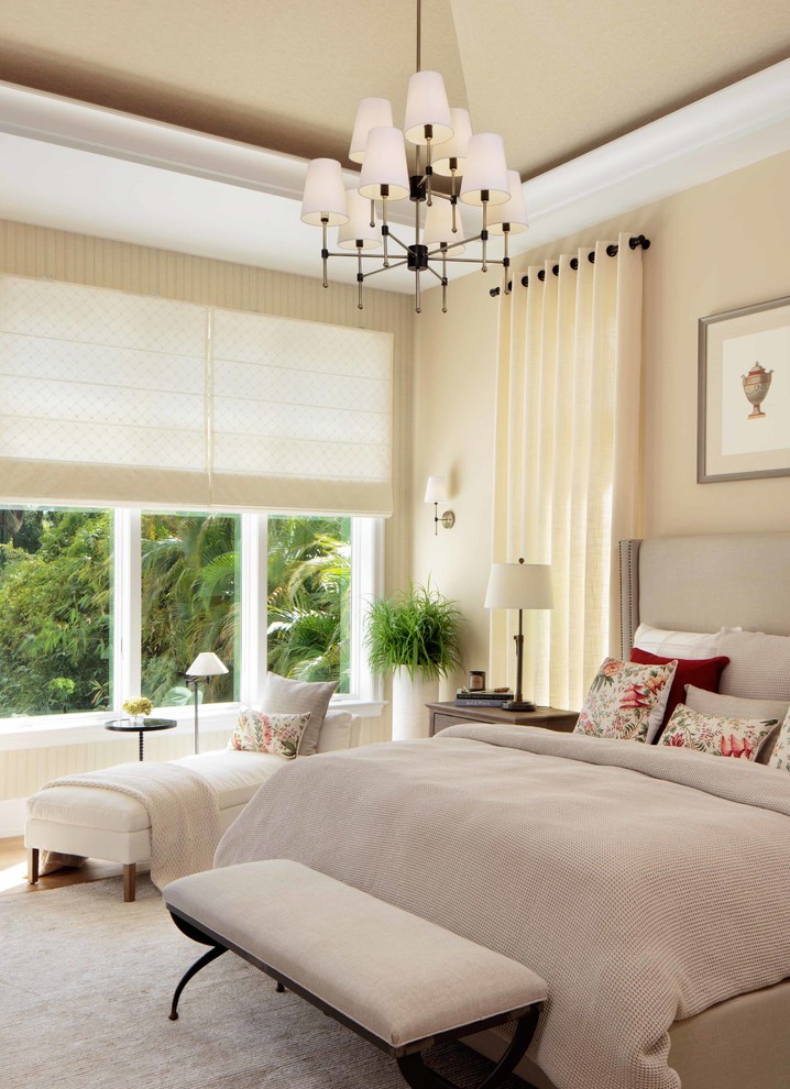 Imagen de dormitorio principal clásico renovado grande con paredes beige y suelo de madera clara