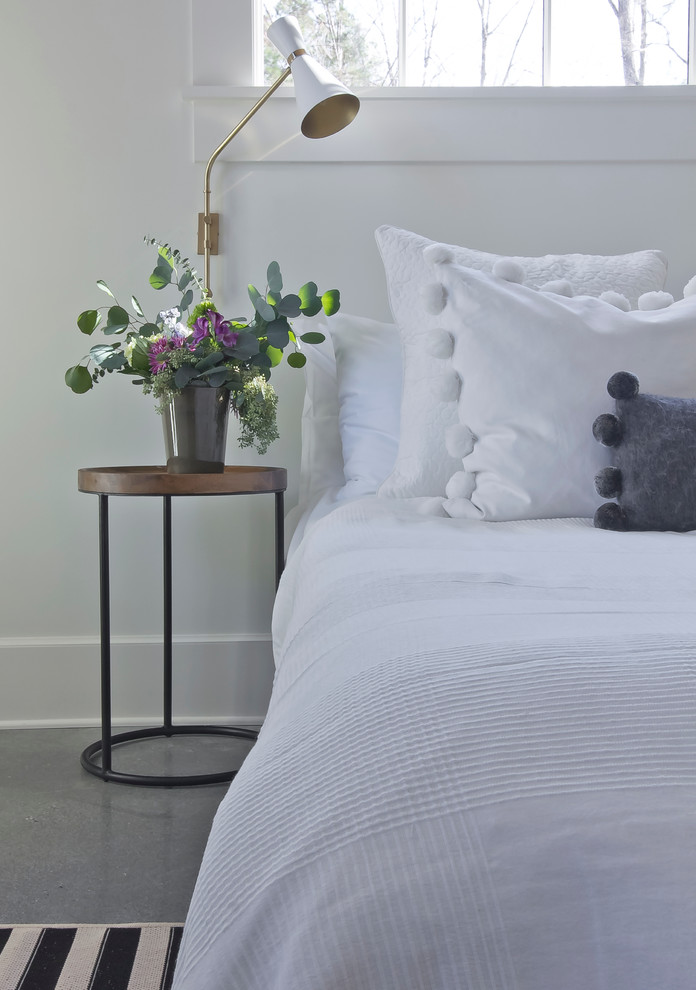 На фото: спальня среднего размера на антресоли в скандинавском стиле с белыми стенами и бетонным полом без камина