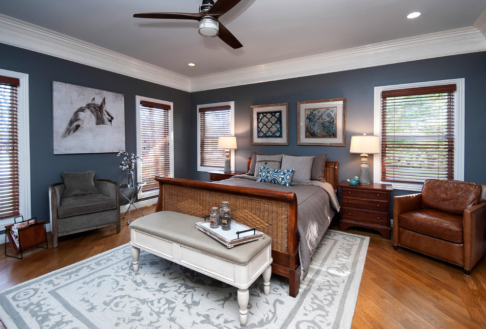 Idée de décoration pour une chambre parentale tradition de taille moyenne avec un mur bleu, un sol en bois brun, aucune cheminée et un sol marron.