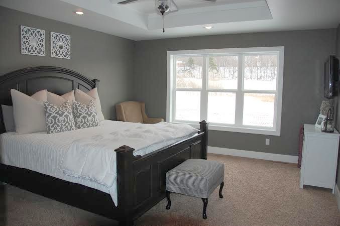Foto på ett amerikanskt sovrum, med grå väggar och heltäckningsmatta
