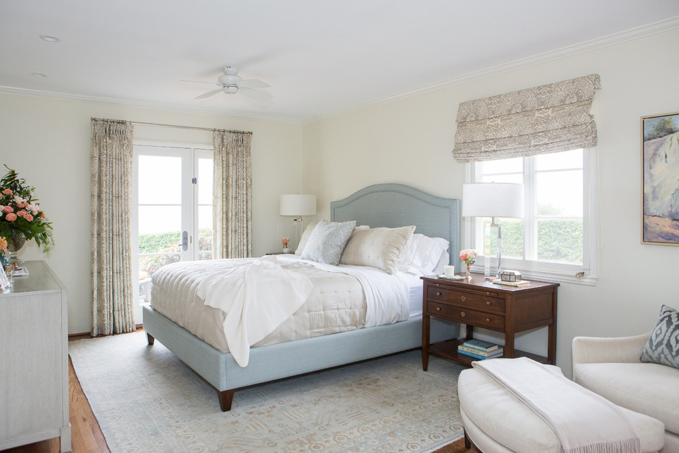 Imagen de dormitorio principal clásico de tamaño medio sin chimenea con paredes beige, suelo de madera en tonos medios y suelo marrón
