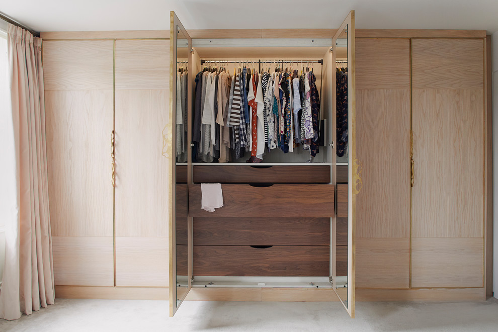 Photo of a medium sized modern wardrobe in London with carpet and beige floors.