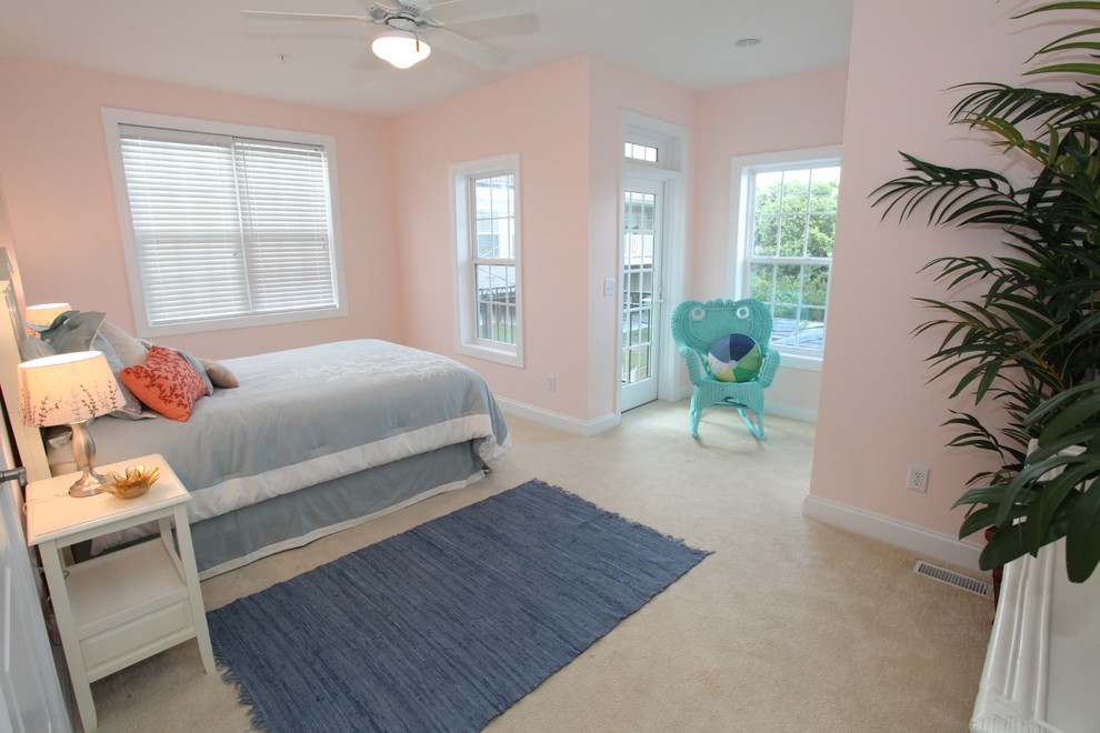 Modelo de habitación de invitados tropical de tamaño medio sin chimenea con paredes rosas y moqueta
