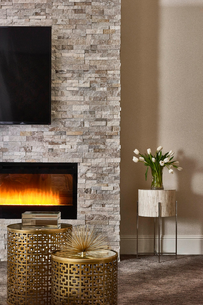 Exemple d'une très grande chambre tendance avec un mur gris, une cheminée standard et un manteau de cheminée en pierre.