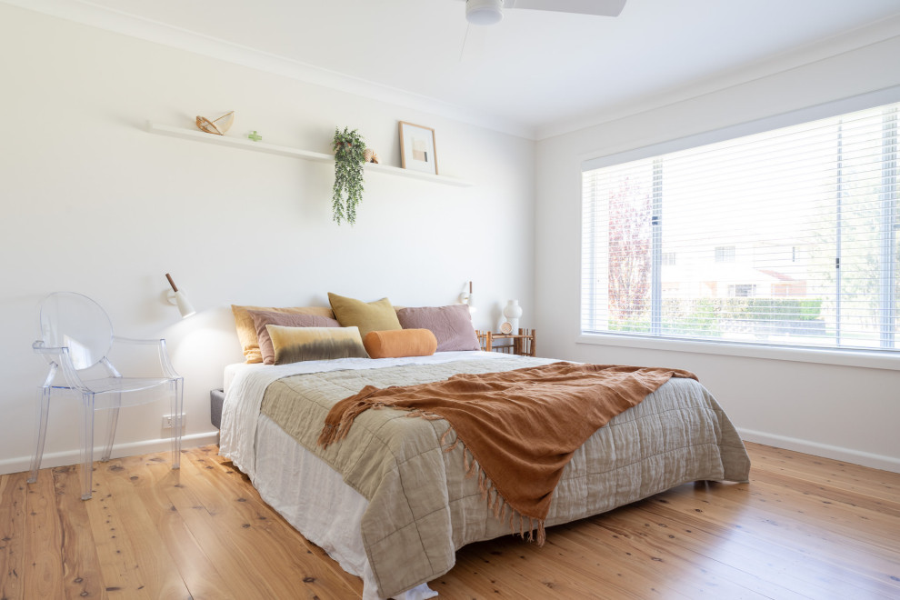 Modernes Schlafzimmer mit weißer Wandfarbe, hellem Holzboden und beigem Boden in Wollongong