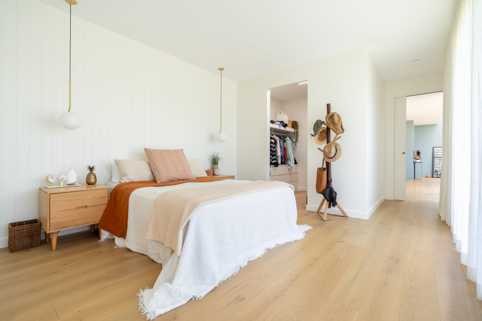 Imagen de dormitorio actual con paredes blancas, suelo de madera clara, suelo beige y machihembrado