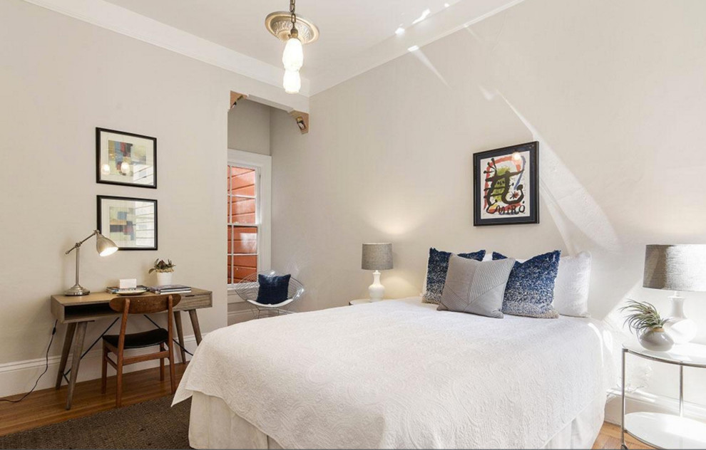 Imagen de habitación de invitados actual grande sin chimenea con paredes grises y suelo de madera en tonos medios