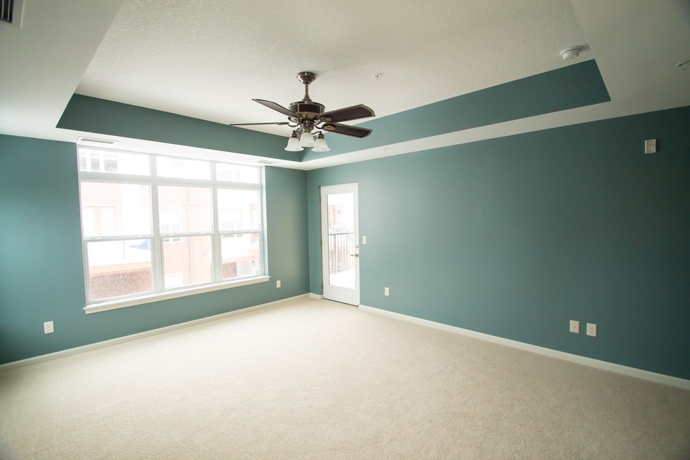 Imagen de dormitorio principal clásico de tamaño medio con paredes azules y moqueta