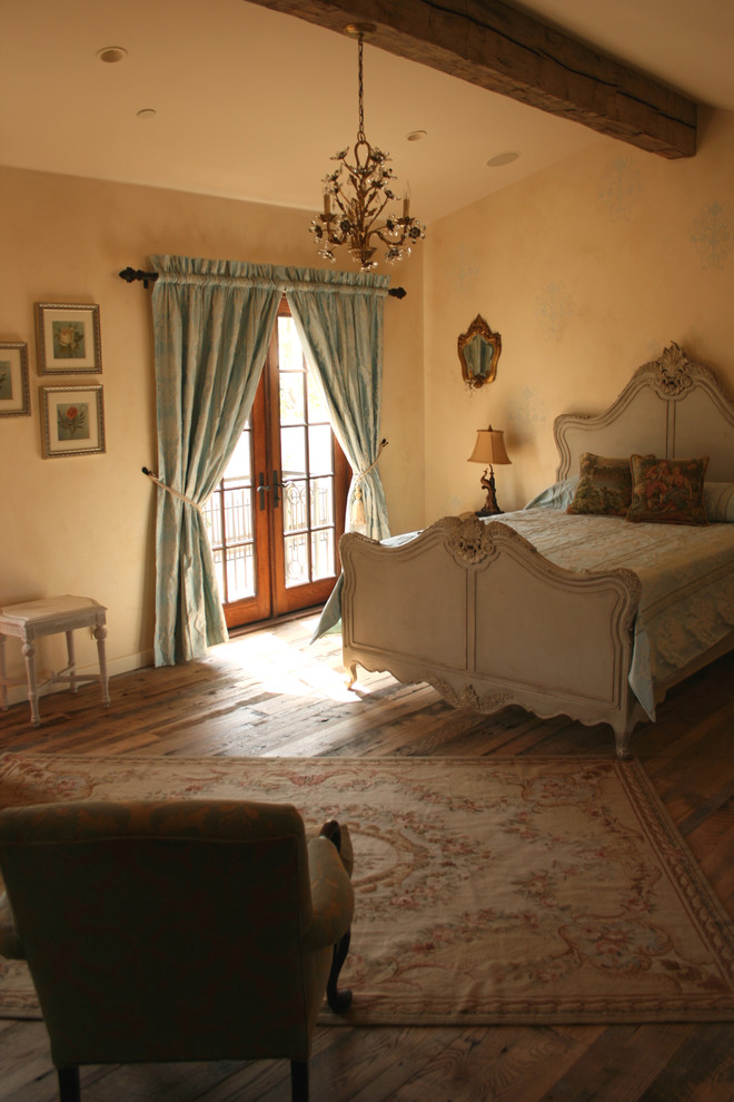 Großes Shabby-Look Hauptschlafzimmer ohne Kamin mit beiger Wandfarbe, dunklem Holzboden und braunem Boden in Orange County