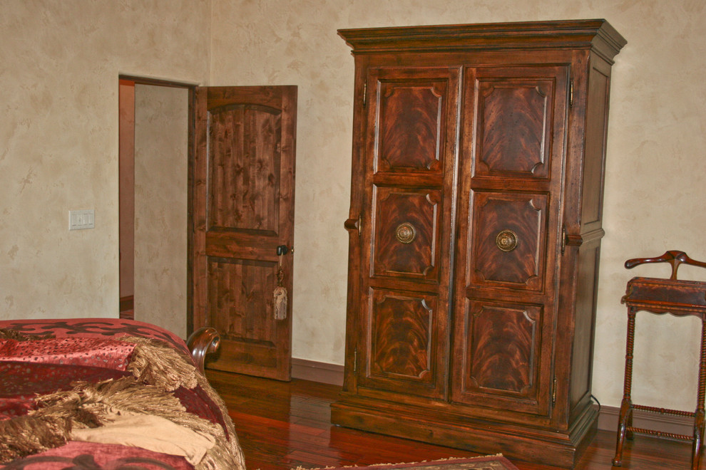 Idée de décoration pour une chambre parentale méditerranéenne de taille moyenne avec un mur beige et parquet foncé.