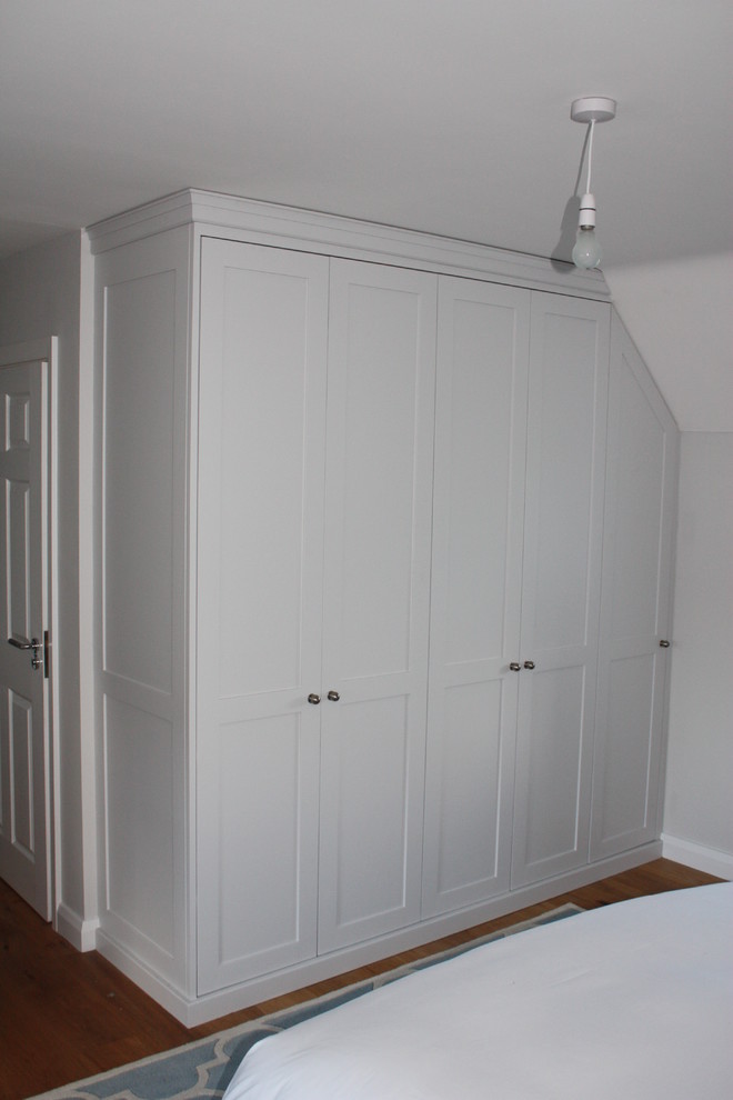 Imagen de dormitorio principal actual de tamaño medio con paredes grises y suelo de madera clara