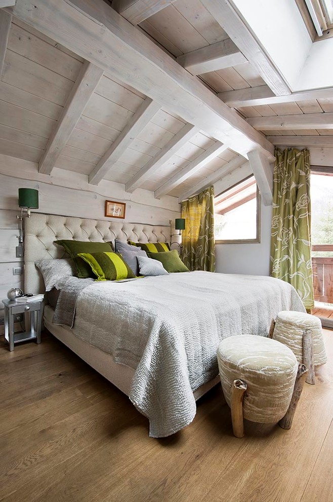 Esempio di un'In mansarda camera matrimoniale country con pareti bianche e pavimento in legno massello medio