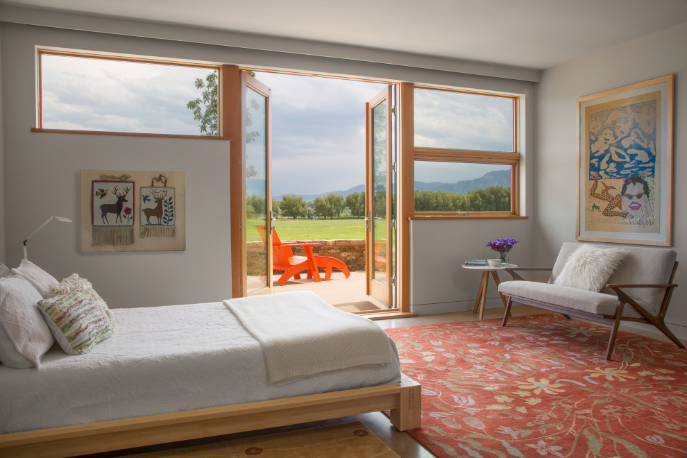 Imagen de habitación de invitados contemporánea extra grande con paredes blancas, suelo de cemento y suelo gris