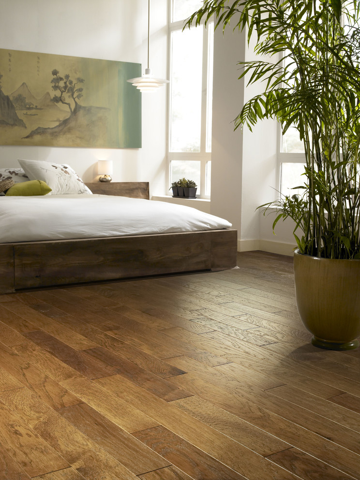 Ejemplo de dormitorio principal de estilo zen grande con suelo de madera en tonos medios y suelo marrón