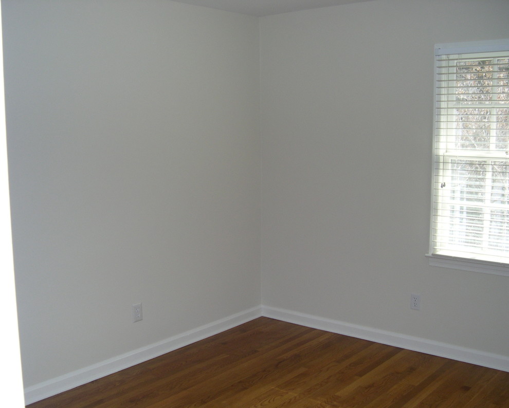 Mid-sized transitional guest medium tone wood floor bedroom photo in Newark with gray walls and no fireplace