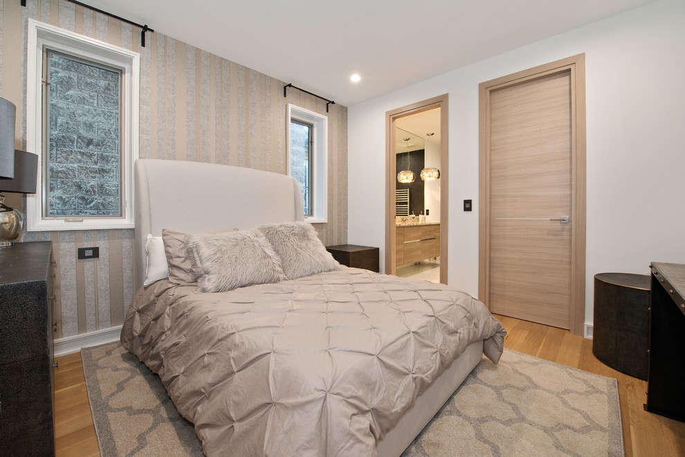 Contemporary guest bedroom in Chicago with white walls, medium hardwood flooring and beige floors.