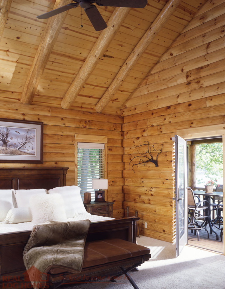 На фото: хозяйская спальня в стиле рустика с ковровым покрытием с