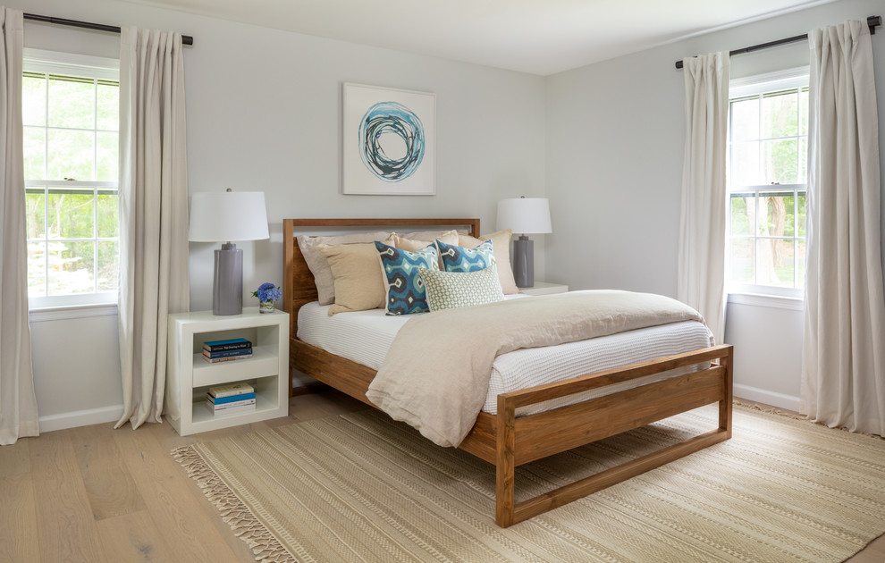 Immagine di una camera da letto costiera con pareti grigie, pavimento in legno massello medio e pavimento marrone