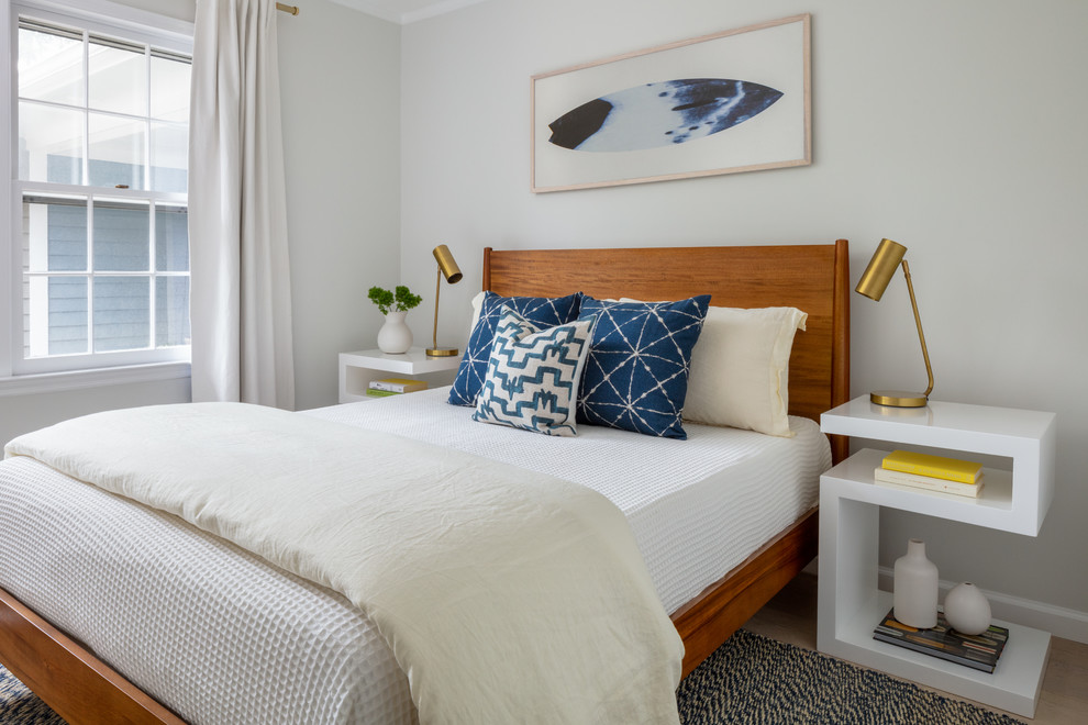 Photo of a coastal bedroom in New York with grey walls, light hardwood flooring and beige floors.