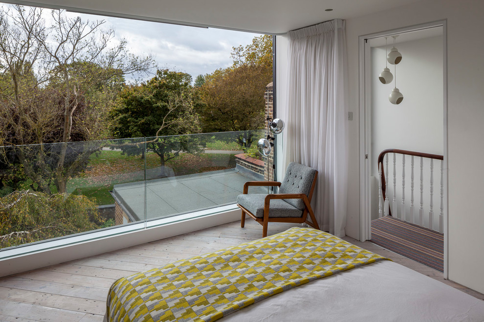 Ejemplo de dormitorio principal minimalista de tamaño medio sin chimenea con paredes blancas, suelo de madera clara y suelo blanco
