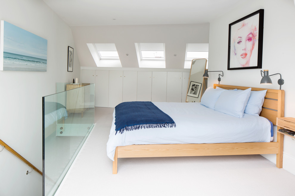 Large contemporary master bedroom in London with grey walls, carpet and beige floors.