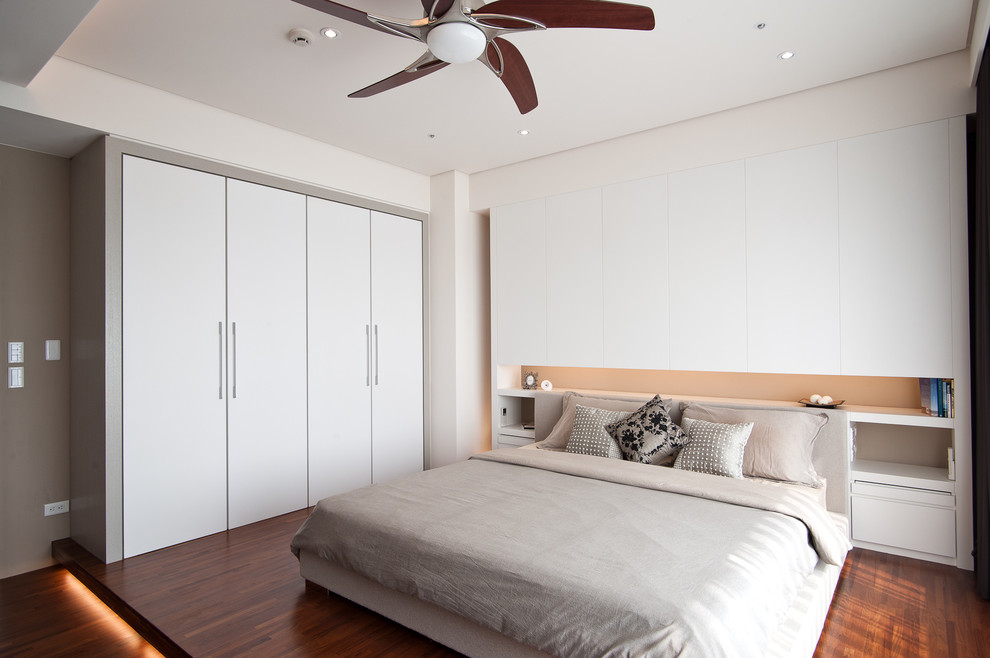 Diseño de dormitorio actual con paredes beige y suelo de madera en tonos medios