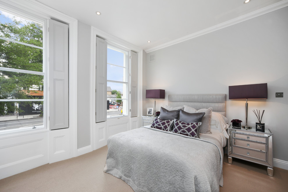 Medium sized contemporary master bedroom in London with grey walls and carpet.