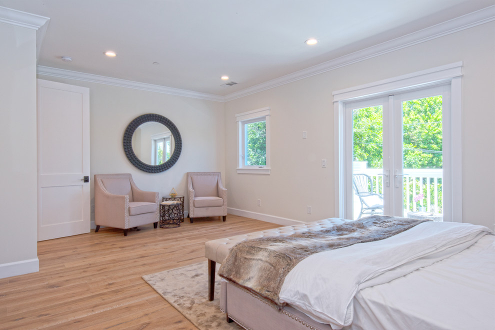 This is an example of a large traditional master bedroom in Los Angeles with beige walls, light hardwood flooring and brown floors.