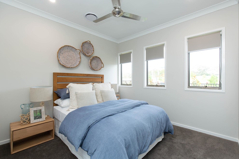 サンシャインコーストにある中くらいなビーチスタイルのおしゃれな客用寝室 (カーペット敷き、グレーの床、ベージュの壁)