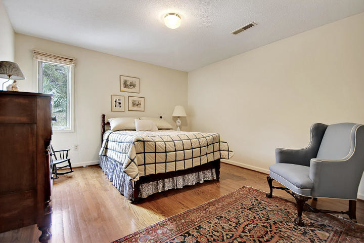 Cette photo montre une chambre d'amis chic de taille moyenne avec un mur beige, un sol en bois brun et aucune cheminée.