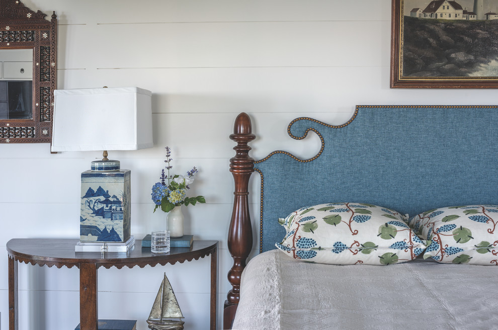 Imagen de habitación de invitados costera de tamaño medio sin chimenea con paredes azules, suelo de madera clara y suelo marrón
