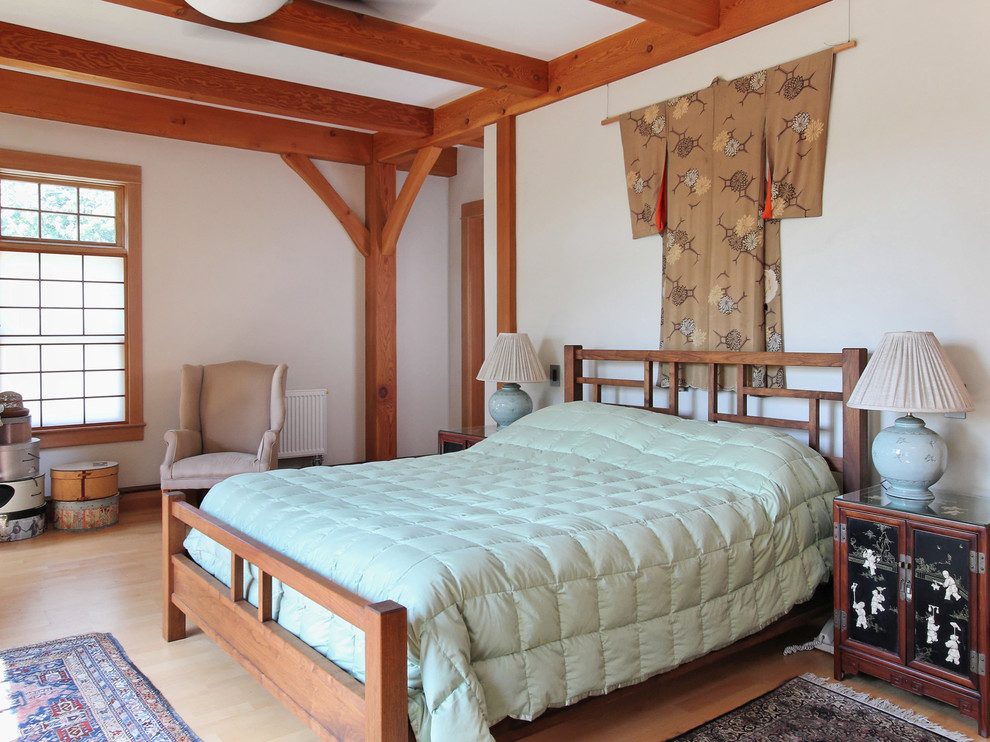 Zen light wood floor bedroom photo in Portland Maine with white walls