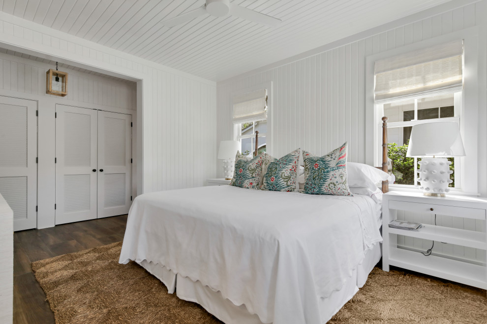 Maritimes Schlafzimmer mit weißer Wandfarbe, braunem Boden, dunklem Holzboden, Holzdielendecke und Holzdielenwänden in Atlanta