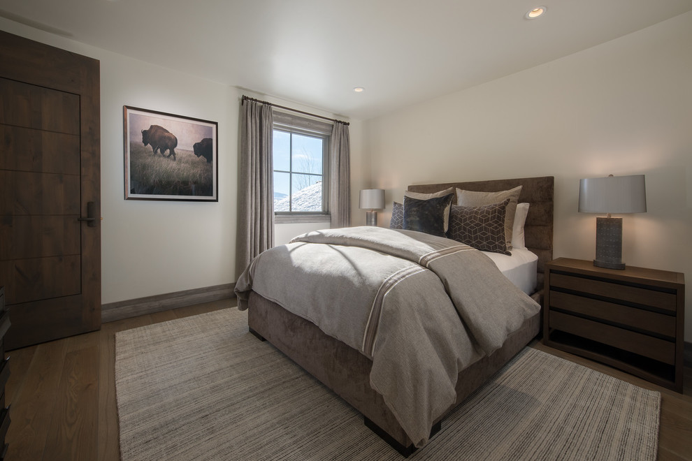 Foto de dormitorio rural con paredes blancas, suelo de madera en tonos medios y suelo marrón