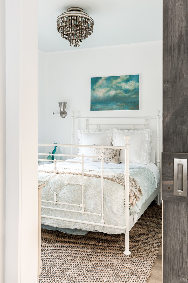Example of a mid-sized beach style master medium tone wood floor bedroom design in New York with white walls