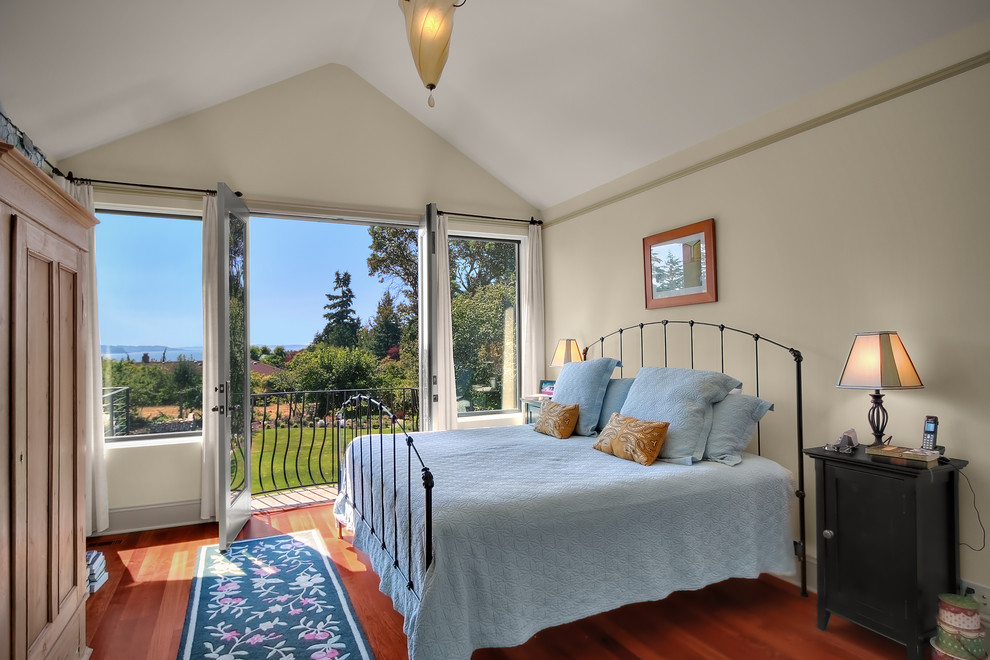 Traditional bedroom in Seattle with beige walls and medium hardwood flooring.