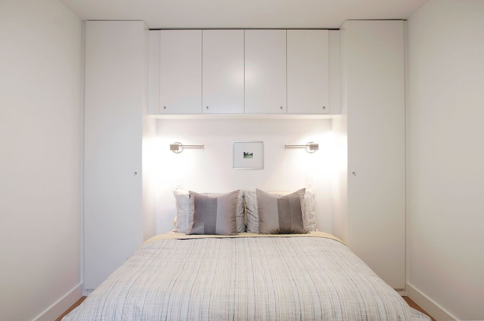 Foto de dormitorio principal contemporáneo pequeño sin chimenea con paredes blancas, suelo de madera en tonos medios y suelo blanco