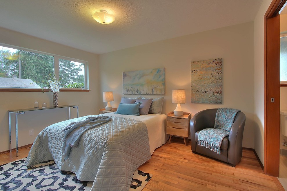 Imagen de dormitorio principal tradicional de tamaño medio sin chimenea con paredes beige y suelo de madera clara