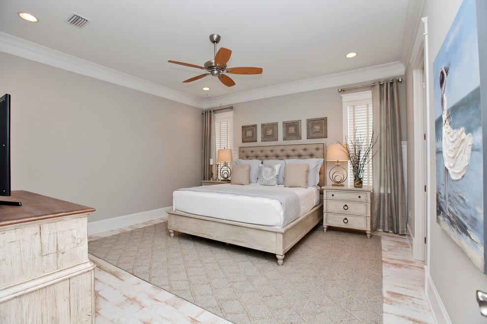 Example of a mid-sized beach style master light wood floor and white floor bedroom design in San Diego with beige walls