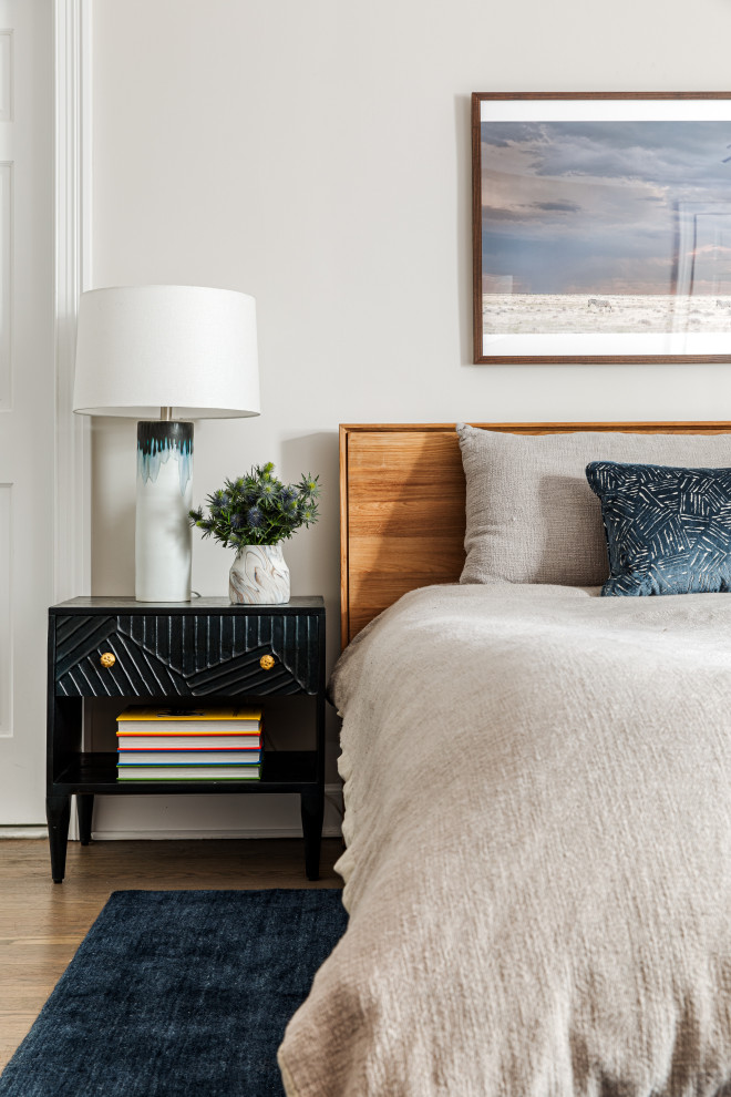 Foto di una camera da letto chic con pareti bianche, pavimento in legno massello medio e pavimento marrone